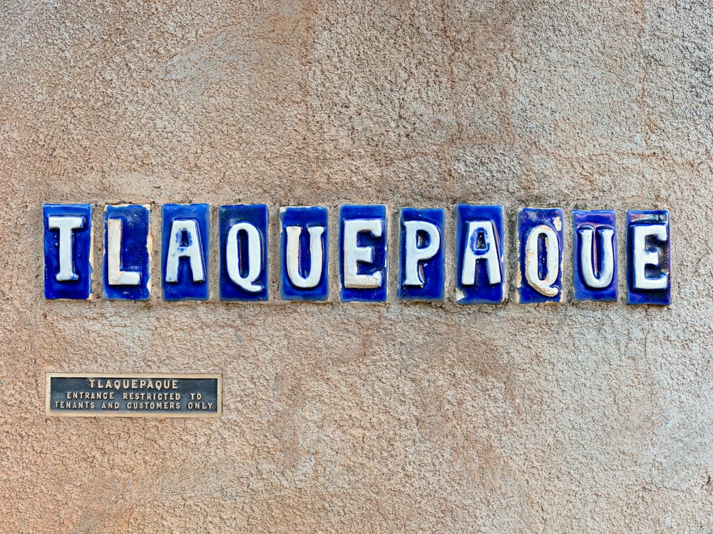 TLAQUEPAQUE tile sign on stucco wall