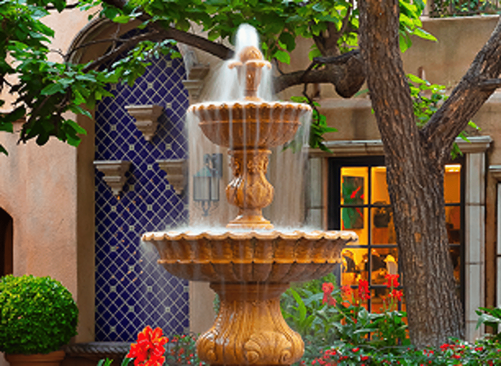 Tiered stone fountain beside cobalt tilework