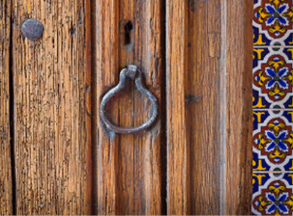 Carved wooden door with iron knocker and Talavera tiles